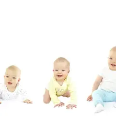 Pięcioro dzieci w różnym wieku, od leżącego niemowlaka po stojące dziecko, ilustrujące skoki rozwojowe.