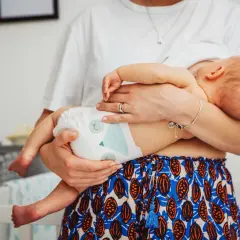Mama tuli dziecko, które mogło się przegrzać. Widać pieluszkę i jej ramiona.