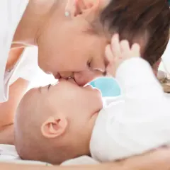 Ciepły uścisk mamy i jej 7 miesięczne dziecko. Delikatne pocałunki i miłość w spojrzeniu.