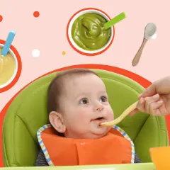 Rozszerzanie diety niemowlaka. Rączka podaje łyżeczkę z jedzeniem ciekawskiemu dziecku w krzesełku. Wokół miseczki z puree.