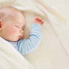 Śpiące dziecko, 22 tydzień życia, otulone w miękki kocyk.
