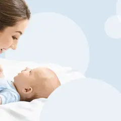 Mama patrzy z miłością na swoje dziecko, które właśnie zaczyna gaworzyć, wydając pierwsze dźwięki radości.