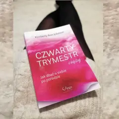 Książka "Czwarty trymestr ciąży" Kimberly Ann Johnson leży na jasnym swetrze.