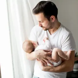Ojciec tuli swojego 5 miesięczne dziecko przy oknie.