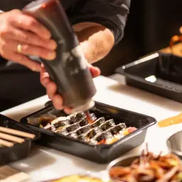 Przygotowanie sushi. Sos wylewany na rolki, jakby matka karmiła piersią swoje dziecko.